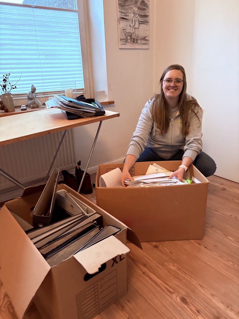 Neele Krichel beim Sortieren von Unterlagen und Ordnern in Umzugskartons